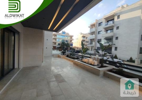 شقة ارضية للبيع في رجم عميش  طريق المطار مساحة البناء 242م ومساحة الحديقة والترس 220م