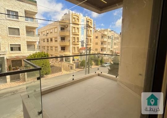 شقة طابق ارضي مع ترس في حي الصحابة تشطيب فخم 